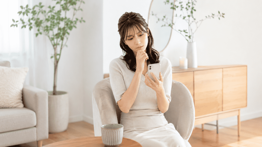 エステの広告を見て悩んでいる女性の画像