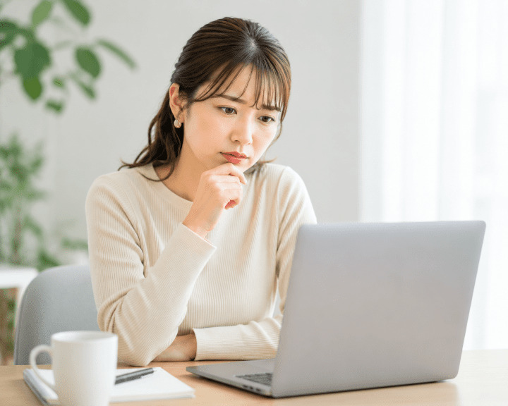 PCを眺める女性の画像