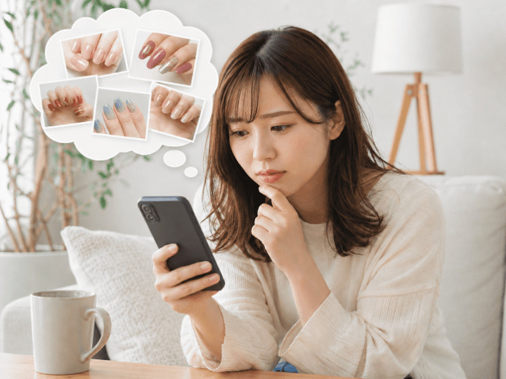 どこのネイルサロンにするか悩んでいる女性の画像